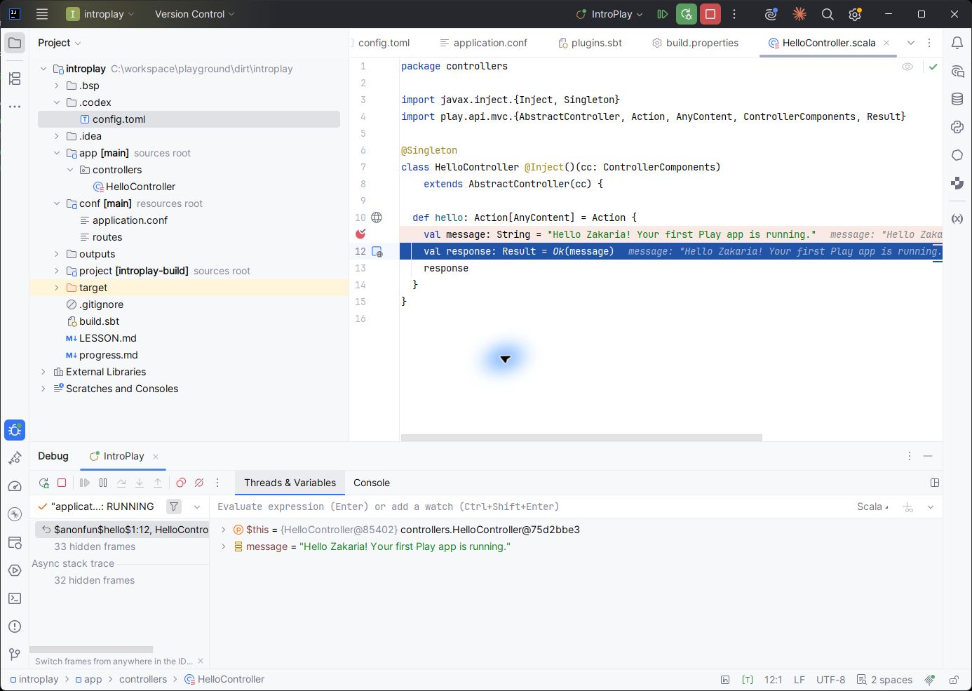IntelliJ debugger paused at line 12 of HelloController, showing the message local variable